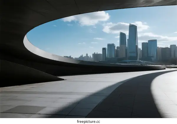Modern cityscape with curved architecture and tall buildings under blue sky