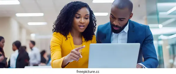 Business Colleagues Working Together on Laptop in Office