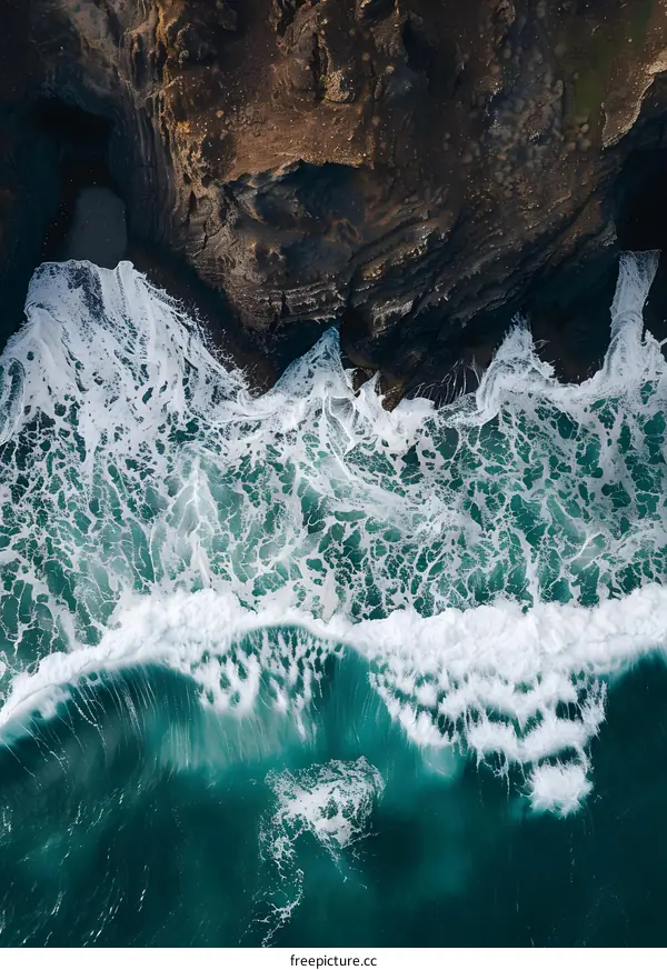 Aerial View of Waves Crashing Against Rocky Cliffs