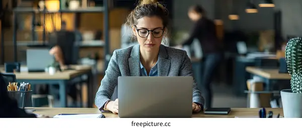 Woman Working on Laptop at Office Desk