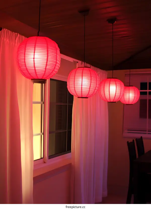 Red Paper Lanterns Hanging in a Room with White Curtains