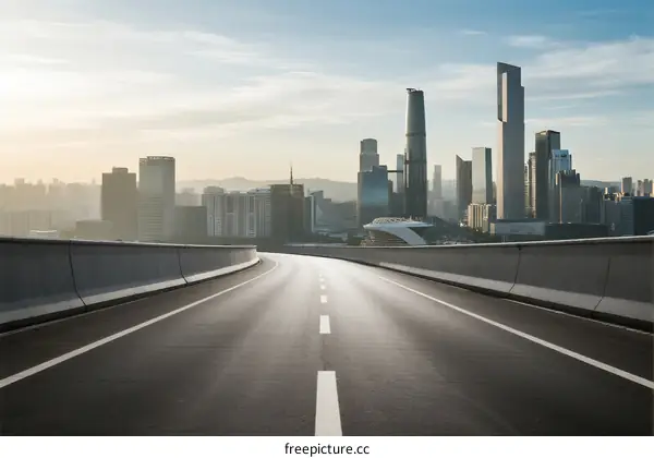 Urban road leading to modern city skyline under clear sky