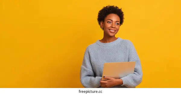 Smiling Woman Holding Laptop Against Yellow Background