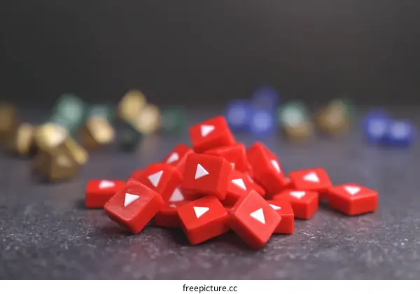 Pile of Red YouTube Play Buttons on Dark Surface