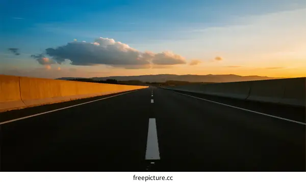 Scenic highway at sunset with clear sky and distant mountains