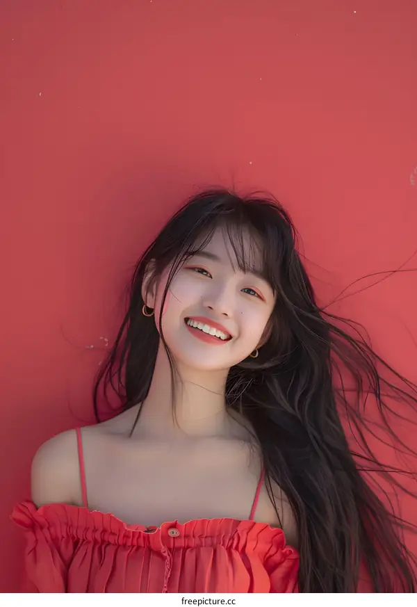 Beautiful Asian Woman with Long Black Hair Smiling Against Red Background