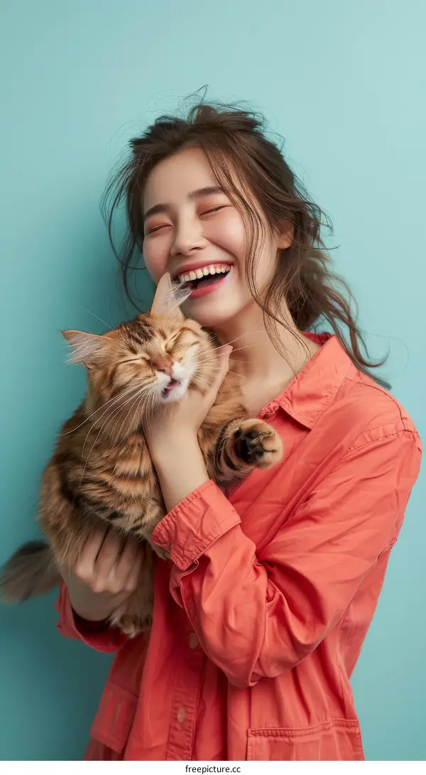 A woman is holding a cat in her arms and smiling.