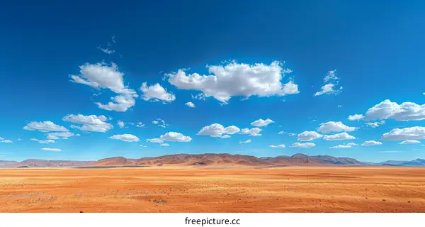 Vast Desert Landscape with Blue Sky and Clouds