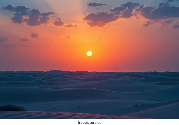 The sun sets over a vast desert landscape