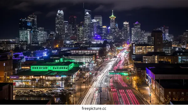 A long exposure photo of a city street at night with colorful light trails from the cars
