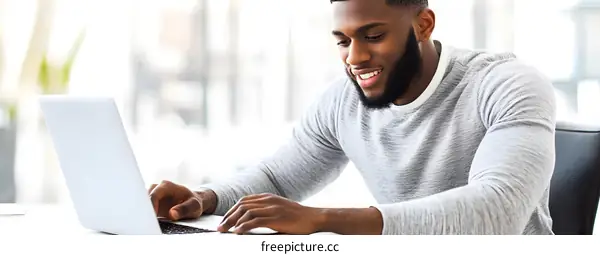Smiling African American Man Working on Laptop
