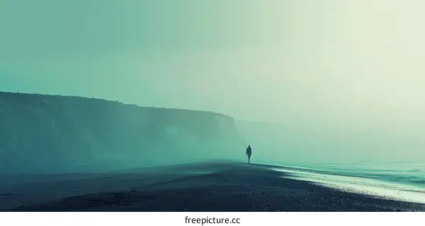 Man walking alone on a beach with a foggy green background
