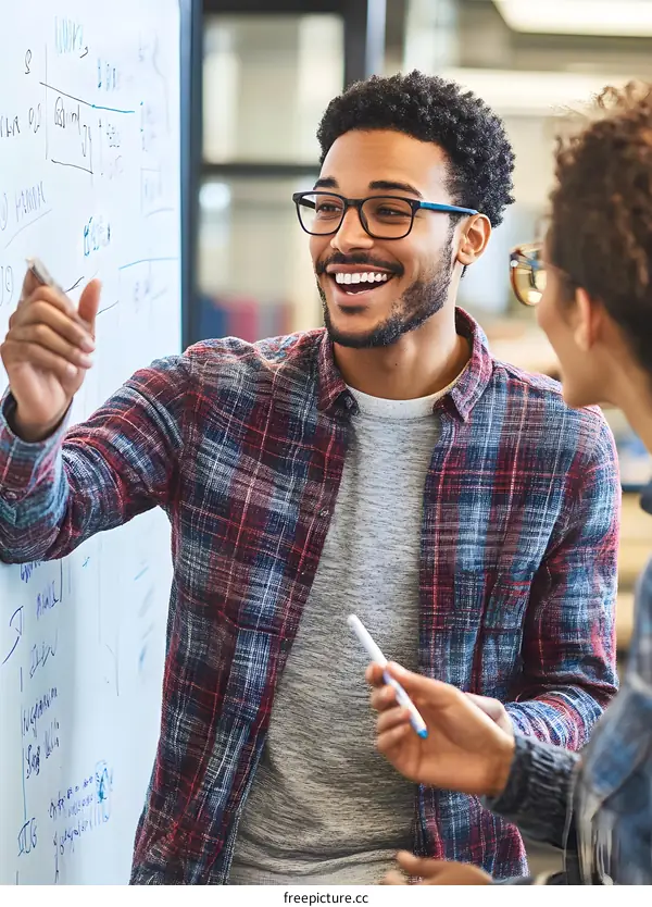 African American Man Discussing Ideas On Whiteboard With Coworker