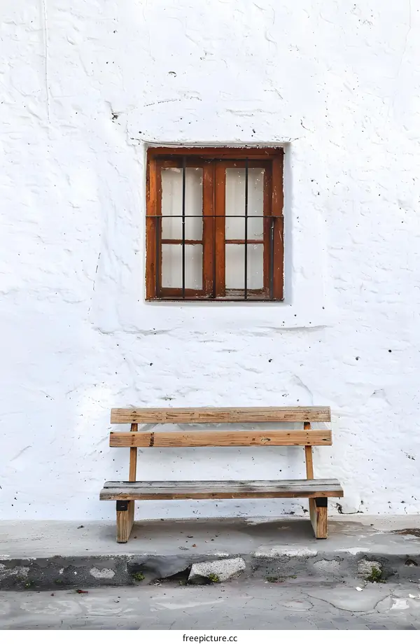Wooden Bench Against A White Wall With A Window