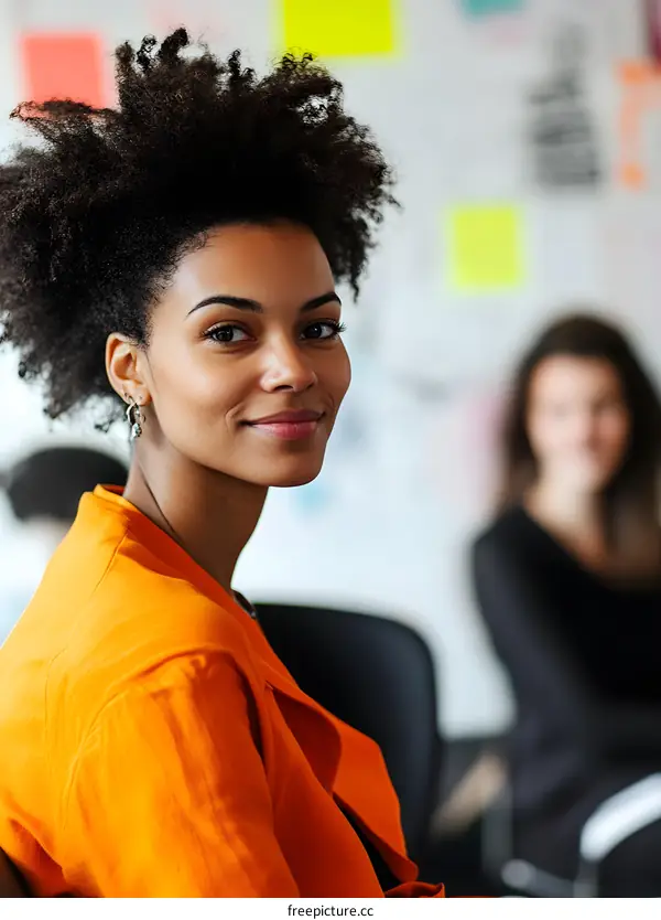 Smiling Black Woman in Orange Jacket at Work