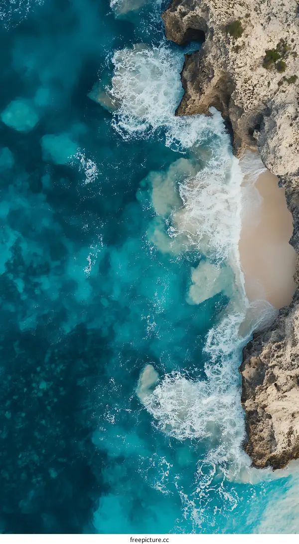 Aerial View of Turquoise Ocean Water and White Waves Crashing on a Rocky Coastline