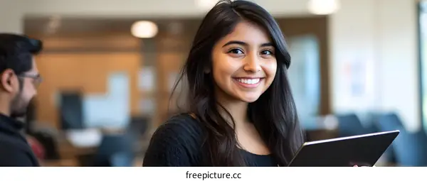 Smiling Young Woman Holding Tablet in Office Setting