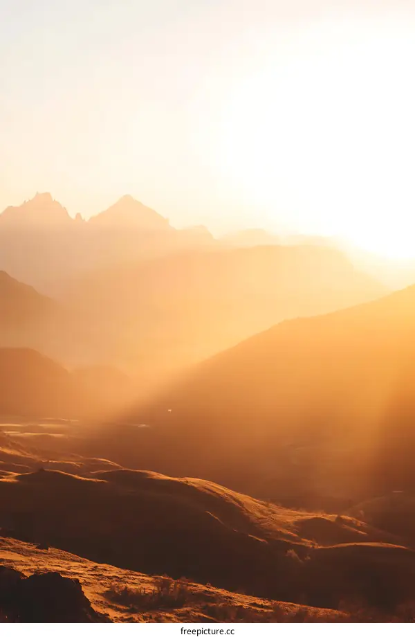 Golden Hour Landscape with Rolling Hills and Mountains