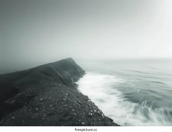 Black and white photo of a rocky coast with a large cliff