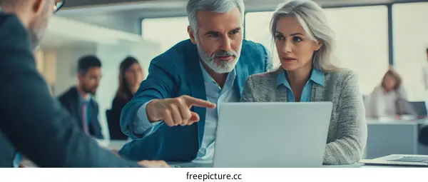 Business Team Discussing Data On Laptop