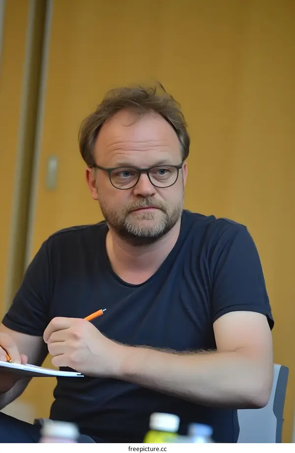 Man with Beard Writing in Notebook