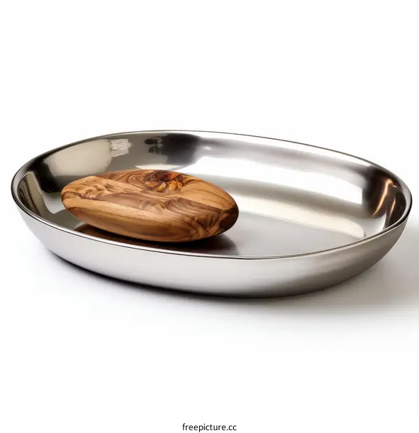 An olive wood soap dish sits in an oval stainless steel bowl