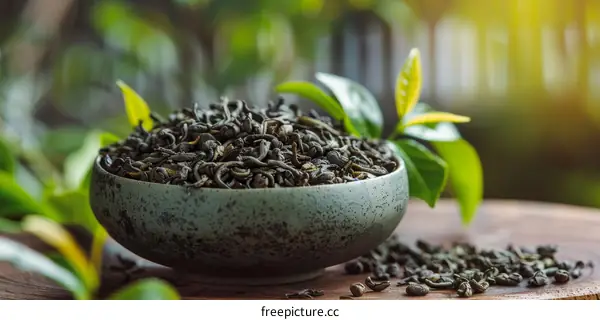 Green tea leaves in a bowl with green tea leaves in the background