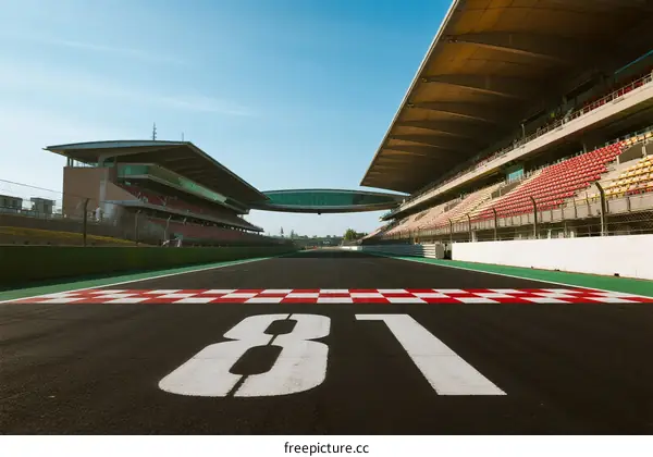 Empty race track with grandstands under clear blue sky