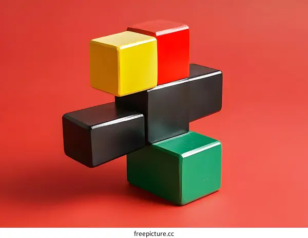 Colorful Wooden Blocks Stacked in a Cross Shape on Red Background