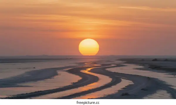Beautiful sunset over a sandy landscape with winding water paths