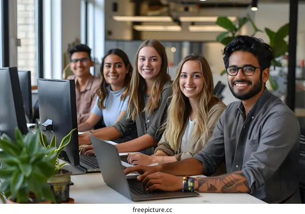 Portrait of a diverse group of young professionals smiling and working together in a modern office