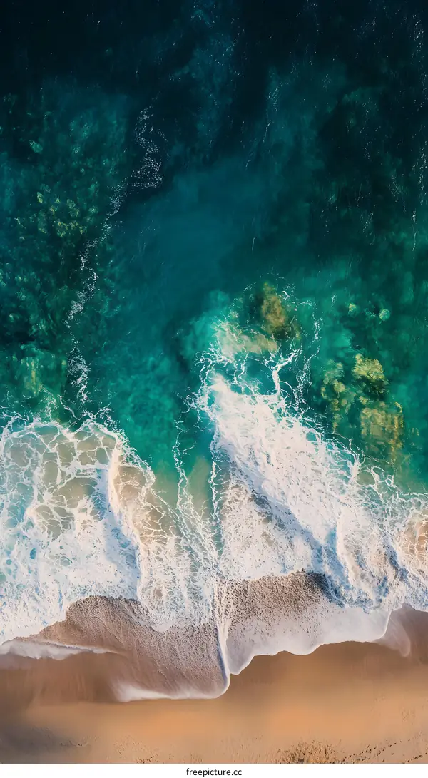 Aerial View of Ocean Waves Crashing on Sandy Beach