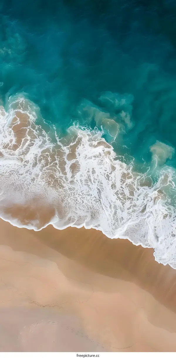 Aerial View of Ocean Waves Crashing on Sandy Beach