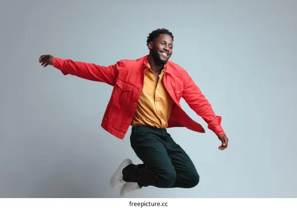 African Man in Stylish Red Jacket Jumping