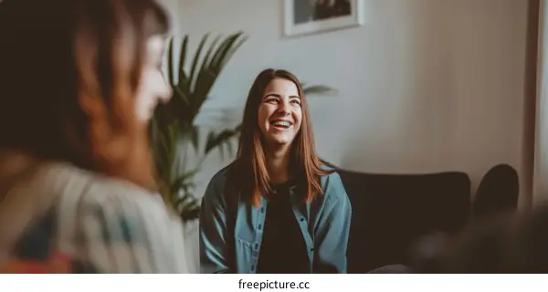 Two young women sitting on a couch and talking