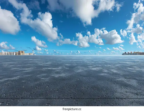Empty Parking Lot with Clear Blue Sky and White Clouds