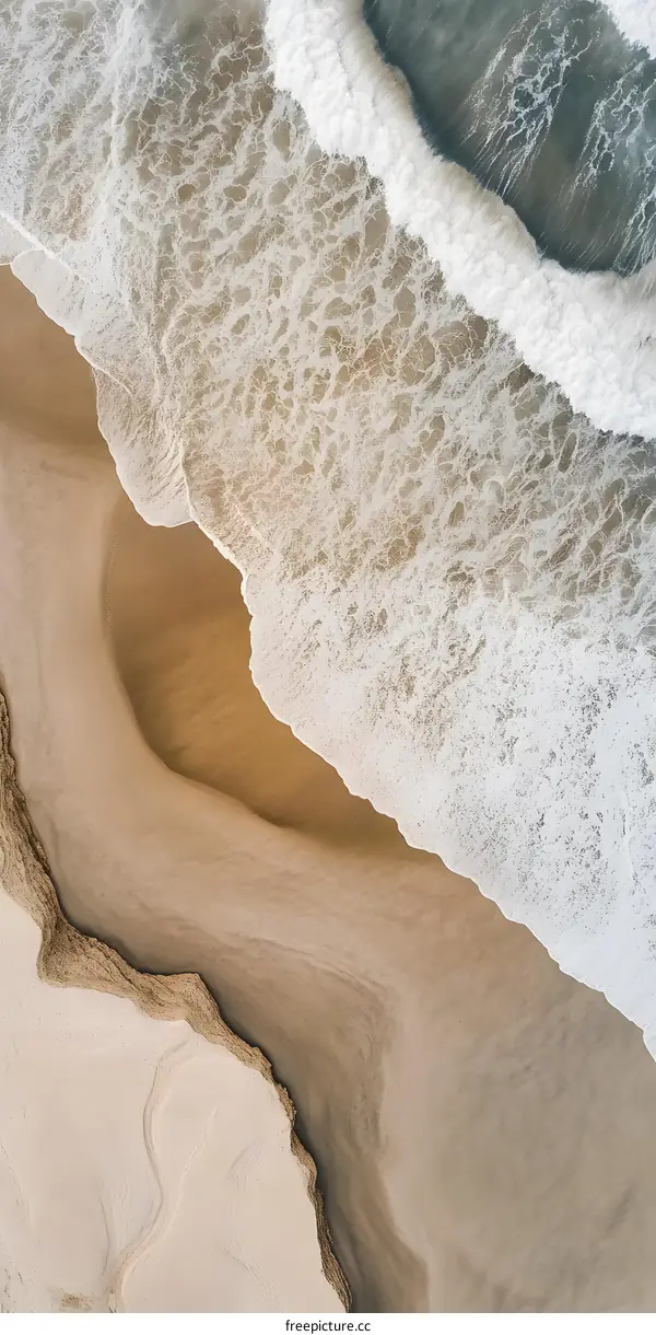 Aerial View of Waves Crashing on Sandy Beach