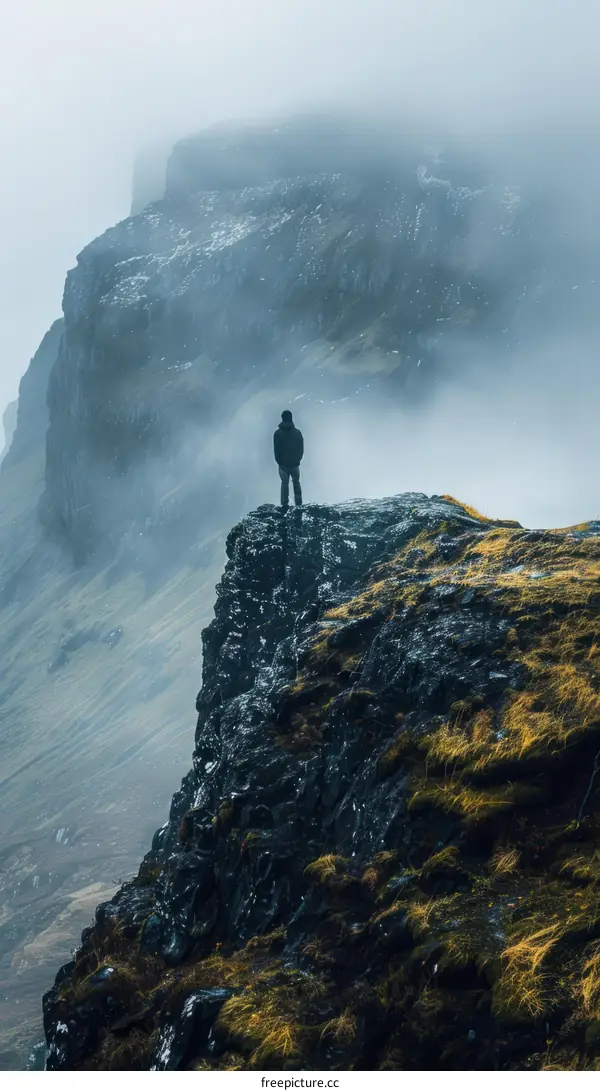 Man standing on a cliff overlooking a valley