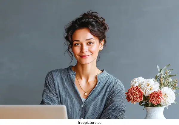 Smiling Woman Working on Laptop with Flowers