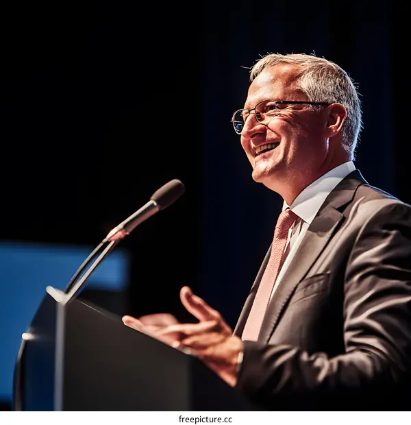 Smiling Businessman Giving a Speech on Stage