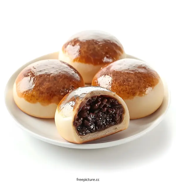 Four pieces of bread with red bean paste filling on a white plate