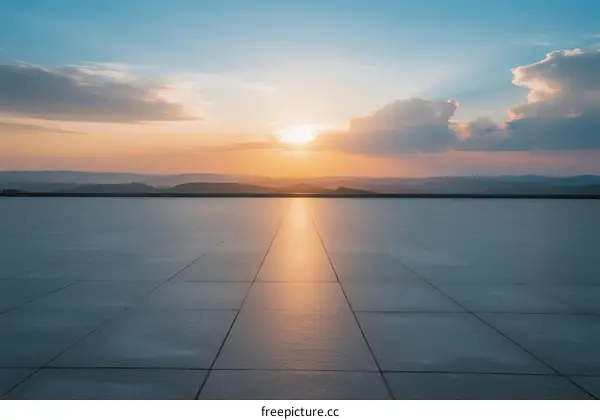 Sunset over a smooth paved area with clouds in the sky