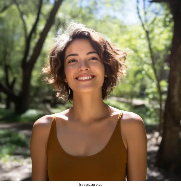 portrait of a smiling young woman in a brown tank top standing in a forest