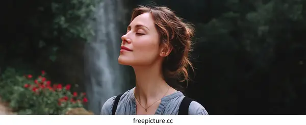 Woman enjoying nature by waterfall