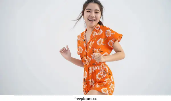 Asian woman in traditional dress smiling and dancing happily