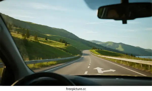 Driving on a scenic road through green hills and open landscape