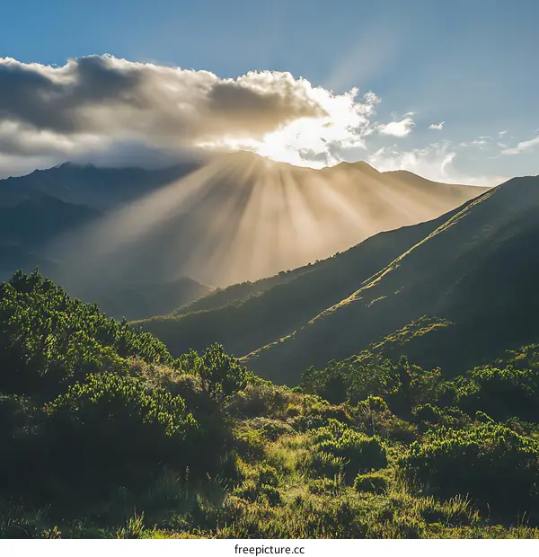 Mountain Range with Sunbeams Shining Through Clouds