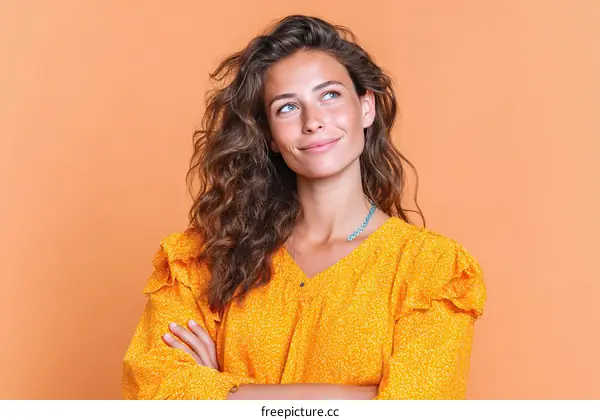Woman in Yellow Dress Posing Against Orange Background