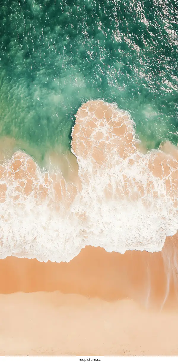 Aerial View of Ocean Waves Crashing on Sandy Beach