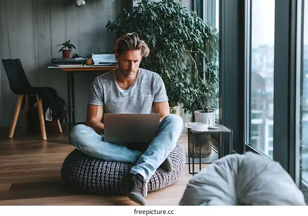 Man Working on Laptop in Cozy Indoor Setting